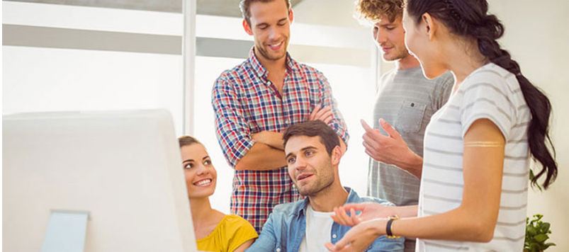 People Sitting in Front of a Computer Screen, Engaged in Discussion