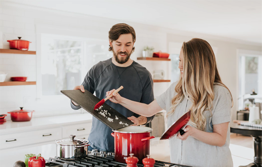 A Boy and a Girl Smiling While Cooking