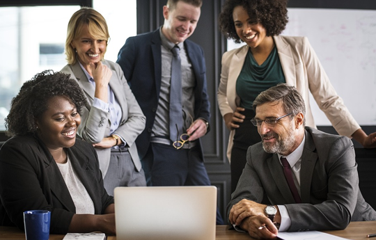 Team Collaboration and Discussion Around a Laptop